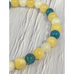 Détail des pierres naturelles jade jaune, pierre de lune et apatite bleue du bracelet Aube sur l’océan.
